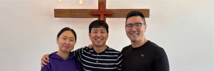 A huband and wife and another man smiling