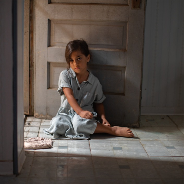 Frightened little girl sitting on the bathroom floor