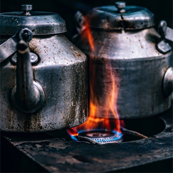 Two old kettle on an old stove top with flames