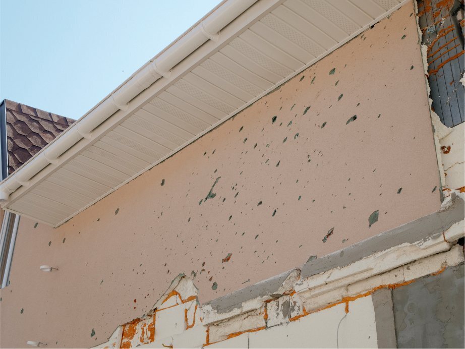 Bullet holes sprayed across the facade of a church building