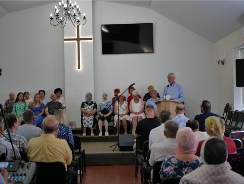 Congregation in church women seated at front pastor at the pupit